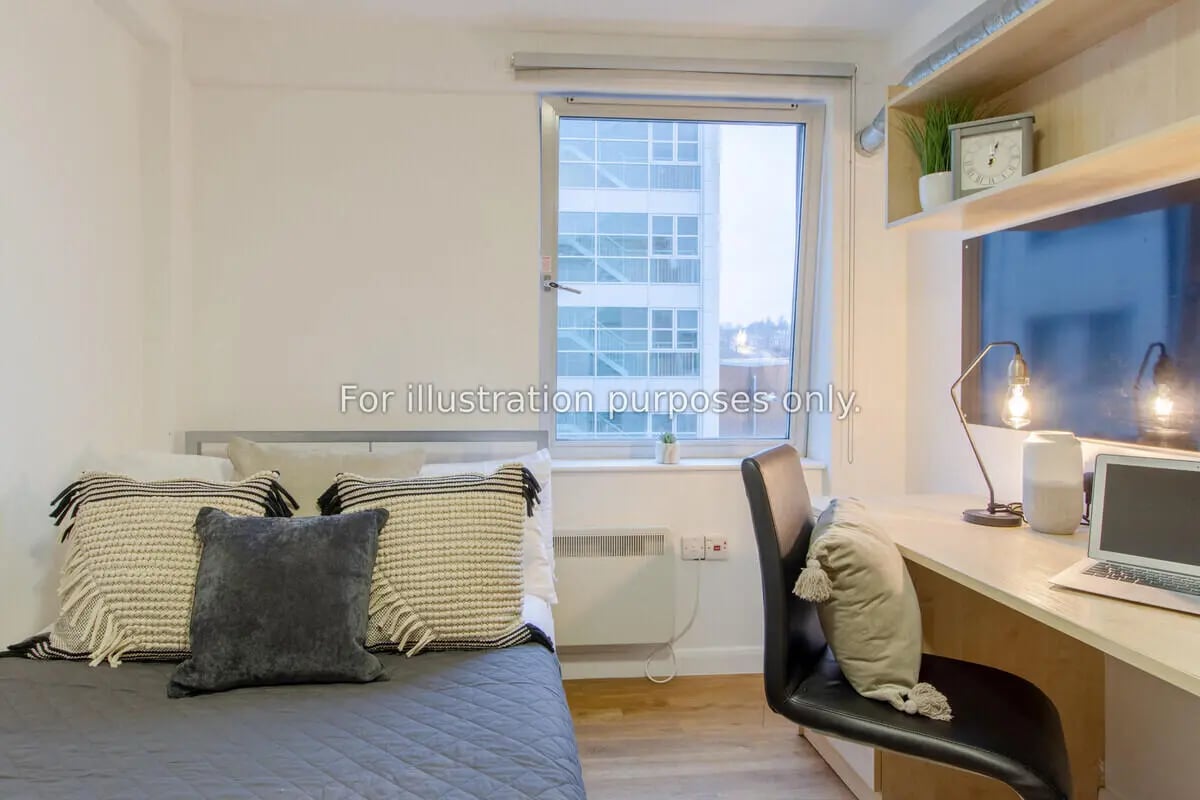 Bed with pillows desk with laptop lamp and chair bedroom at The Glasshouse in Nottingham Student Accommodation