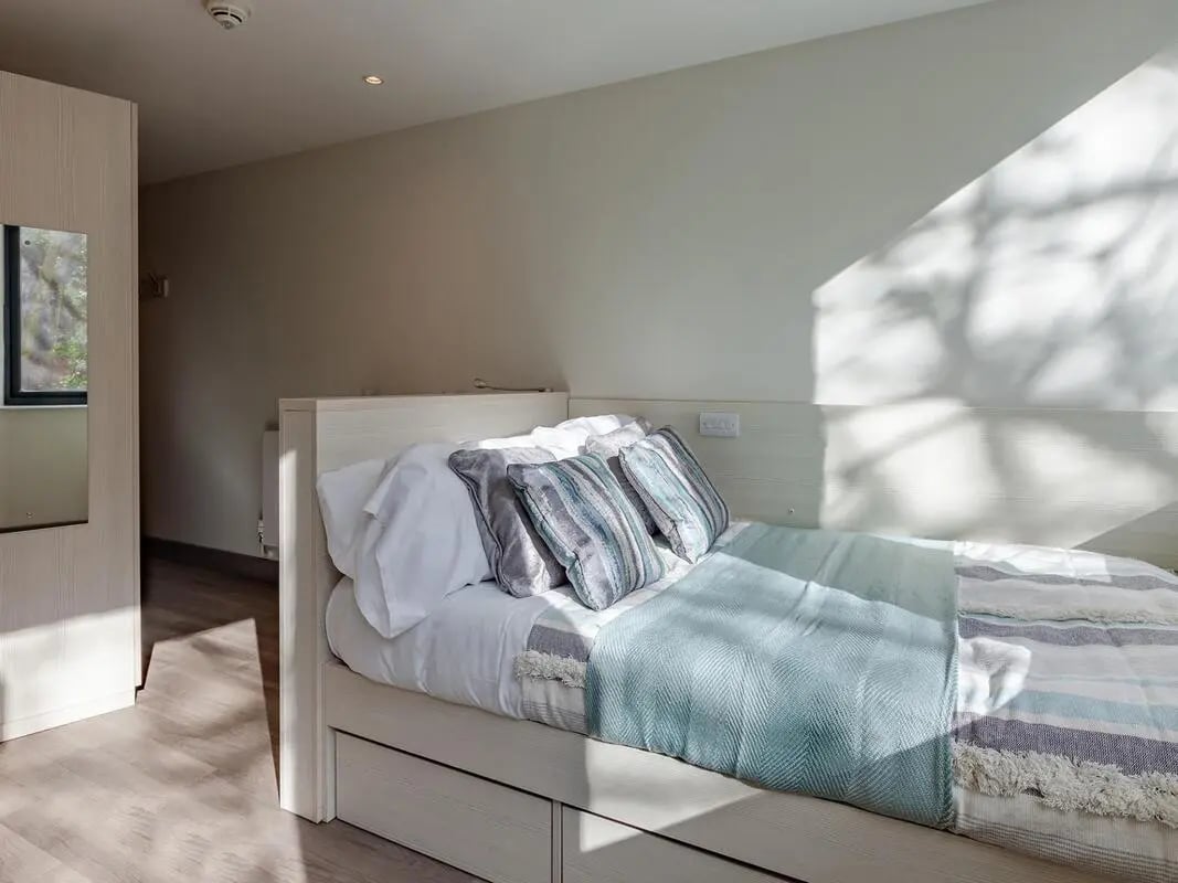 Bed with pillows blankets and storage drawers bedroom at Mercury House in Bournemouth Student Accommodation