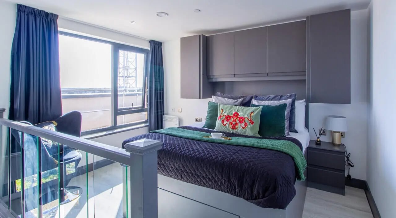 Bed with green throw pillows and nightstand Bedroom at 33 Parkside in Coventry Student Accommodation
