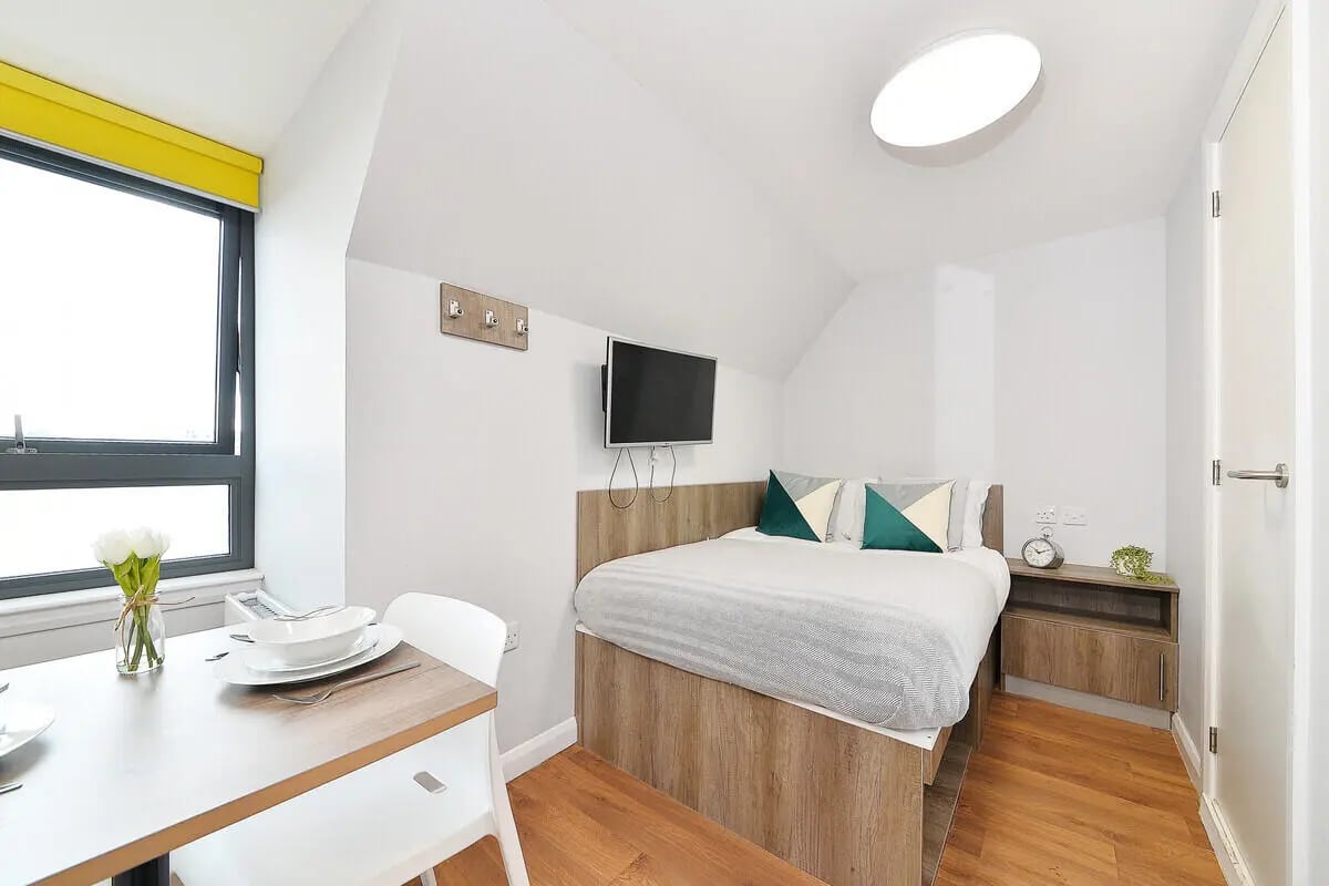 Bed with green pillows side table bedroom at The Mill House in Edinburgh Student Accommodation