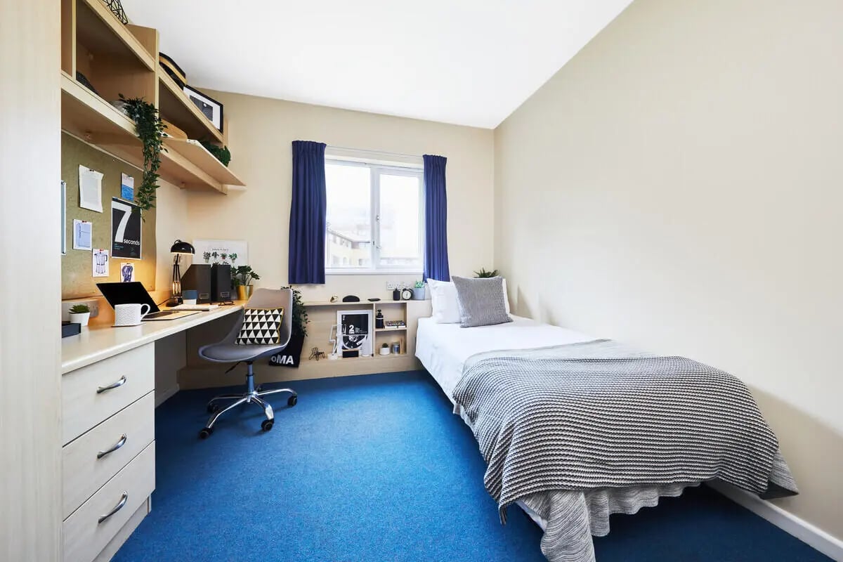 Bed desk chair and shelves student bedroom at Collegiate Upper Quay House in Gloucester Student Accommodation