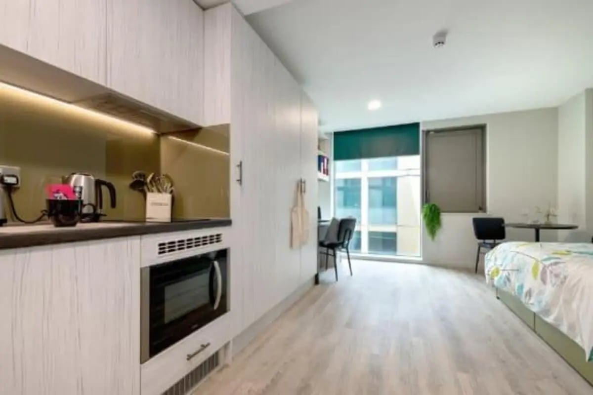 Modern kitchen counter microwave and bed bedroom at Flora Building - Hoxton in London Student Accommodation