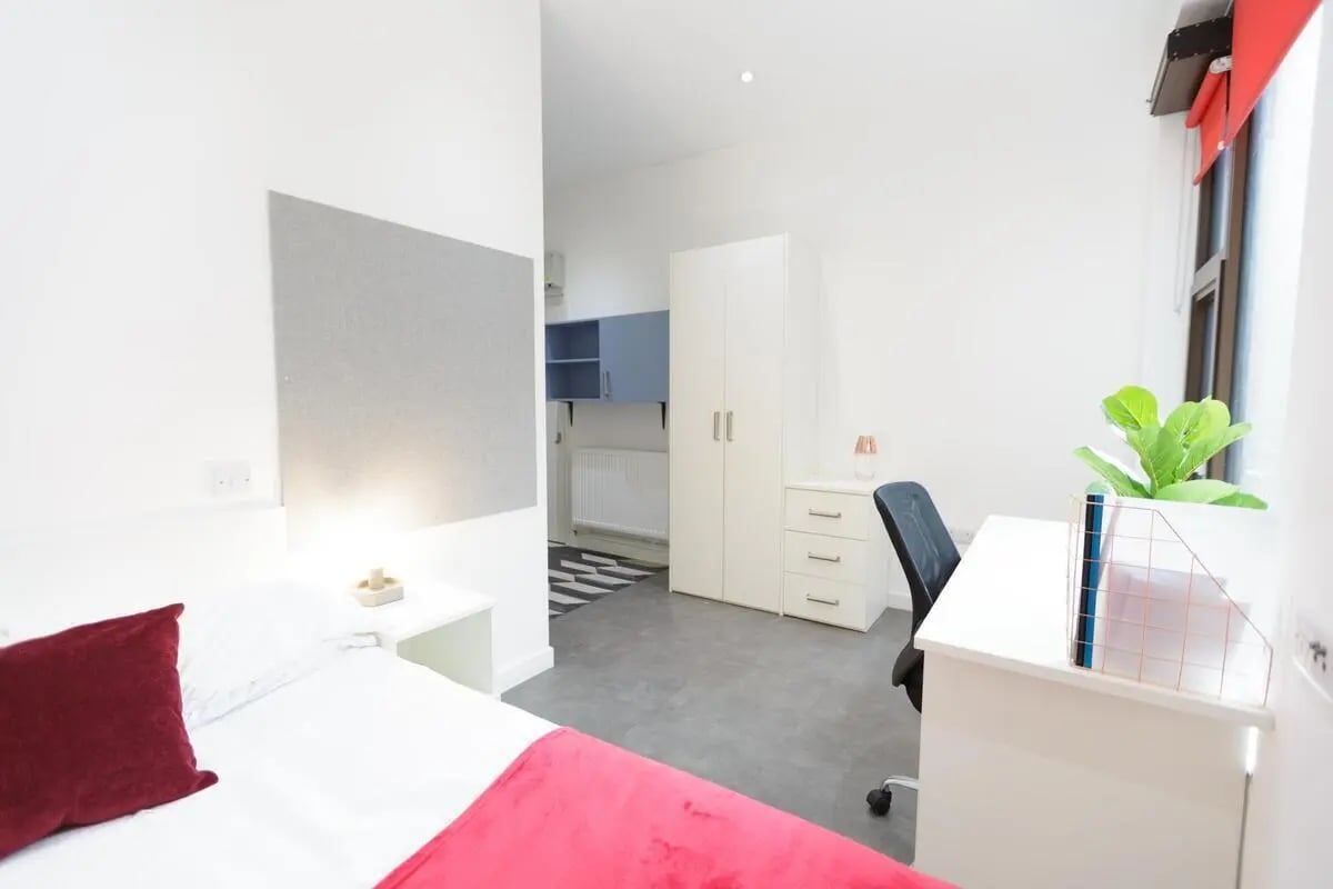 Bed desk wardrobe chair plant bedroom study area at AXO New Cross in London Student Accommodation