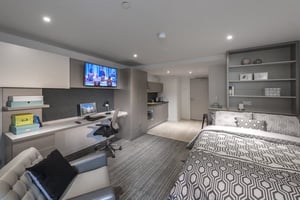 Bed desk kitchen sofa and TV living room at CitySide in Leeds Student Accommodation