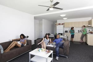 People relaxing in a common area with kitchen living room at Murdoch University Village in Perth Student Accommodation