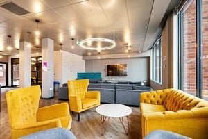 Yellow chairs grey sofas television lounge area at Coppergate Swansea in Swansea Student Accommodation