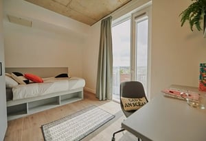 Bed with pillows rug chair desk bedroom at The Loom in Dublin Student Accommodation