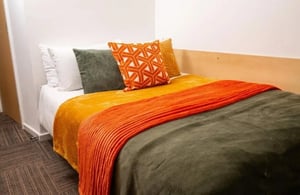 Bed with colorful throws pillows and carpet bedroom at Marybone Student Village 3 in Liverpool Student Accommodation