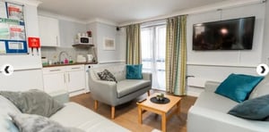 Kitchen sofas coffee table and TV living room at Coopers Court in London Student Accommodation