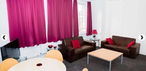Brown sofas red cushions coffee table television living room at Alliance House in London Student Accommodation