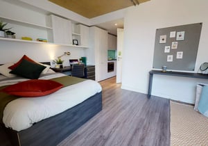Bed desk and kitchen area view interior at iQ Aldgate in London Student Accommodation