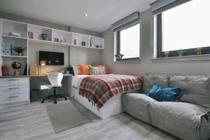 Bed desk chair shelves couch bedroom at George Street Apartments in Glasgow Student Accommodation