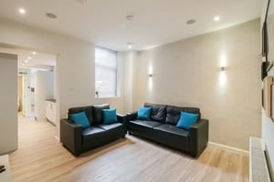 Two black sofas with blue cushions living room at 51 Beresford Street in Stoke-On-Trent Student Accommodation