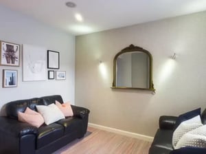 Black couches framed art mirror living room at 41 Crowther Street in Stoke-On-Trent Student Accommodation