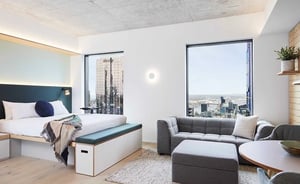 Bed sofa table and city view living room at Scape Franklin in Melbourne Student Accommodation