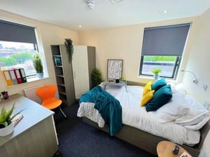 Bed with tray laptop desk and closet bedroom at Stratus in Sheffield Student Accommodation