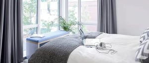 Bed with laptop headphones bench window Bedroom at Lace Market Studios in Nottingham Student Accommodation