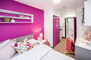 Bed with colorful pillows desk and bathroom bedroom at Crosstrend House in Lincoln Student Accommodation