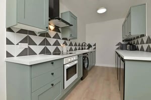 Green cabinets oven sink and washing machine kitchen at Isca Lofts in Exeter Student Accommodation