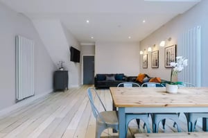 Sofa dining table and radiator living room at 86 Woodcroft Road in Liverpool Student Accommodation
