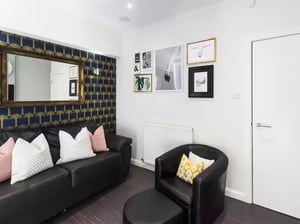 Black leather sofa armchair ottoman gallery wall living room at 41 Guildford Street in Stoke-On-Trent Student Accommodation