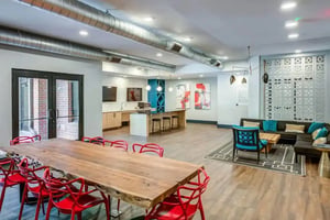 Dining table red chairs kitchen area living area interior at Signature 1505 (Theory) in Raleigh Student Accommodation
