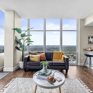 Black sofa with throw pillows and plants living room at 21 Rio in Austin Student Accommodation