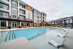 Apartment building pool with lounge chairs exterior at Eastern on 10th in Greenville Student Accommodation