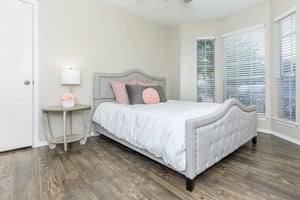 Tufted bed white comforter bedside table bedroom at Villas at Shadow Oaks in Austin Student Accommodation
