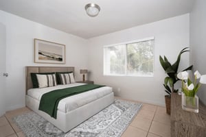 Bed with green throw patterned rug bedside lamp Bedroom at Newport Square Apartments in Colorado Springs Student Accommodation