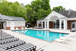 Pool lounge chairs and umbrellas exterior at University Village at Greensboro in Greensboro Student Accommodation