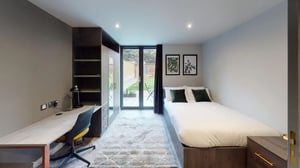 Bed with desk wardrobe and garden view bedroom at Astra House in London Student Accommodation
