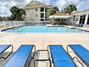 Blue lounge chairs by swimming pool exterior at Tivoli Orlando in Orlando Student Accommodation
