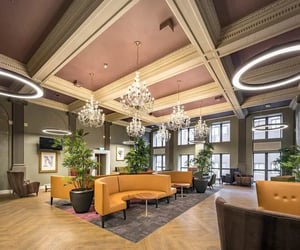 Chairs tables plants chandeliers modern lights lounge area at Collegiate Plummer House in Newcastle Upon Tyne Student Accommodation
