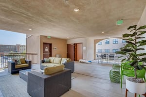 Sofa tables chairs planters balcony living room at Cerca in San Diego Student Accommodation