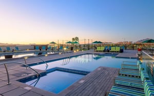 Pool with lounge chairs and umbrellas exterior at The Mark at Tucson in Tucson Student Accommodation