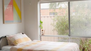 Bed with striped duvet and wall art Bedroom at La Trobe University Regional Housing - Ballarat in Melbourne Student Accommodation