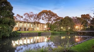 Building by water with trees and bridge Exterior at La Trobe University - Glenn College in Melbourne Student Accommodation