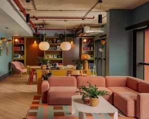 Pink couches shelves table chairs living room at Scape Hammersmith in London Student Accommodation