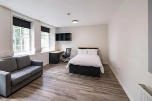 Grey sofa bed desk chair shelving bedroom living room at Lyon Street Terrace in Dundee Student Accommodation
