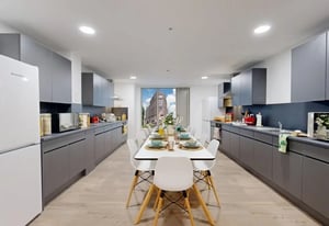 Dining table with chairs and modern kitchen amenities kitchen at Brigg Point in Bristol Student Accommodation