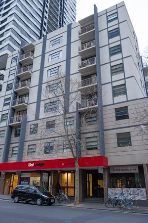 Apartment building with balconies and street level shops exterior at Student Living On ABeckett in Melbourne Student Accommodation