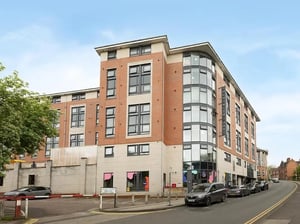 Brick building with many windows and cars Exterior at Yugo Goldsmith Court in Nottingham Student Accommodation