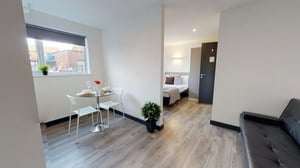 Dining table with chairs bed sofa studio apartment at Opto village in Luton Student Accommodation