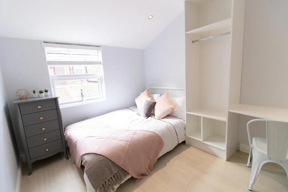 Bed with pink throws desk and wardrobe bedroom at 6 Bedroom House at 85, Halsbury Road in Liverpool Student Accommodation