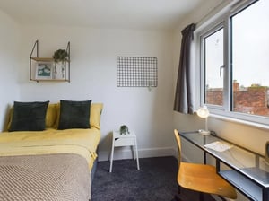 Bed with yellow bedding desk and chair bedroom at 4 Bedroom House at Flat 5, 265, Edge Lane in Liverpool Student Accommodation