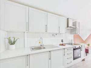 White cabinets sink stove and plant kitchen at 1 Bedroom House at Flat 19, Grove Street Studios, The Groves in Liverpool Student Accommodation