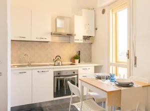 Modern kitchen with white cabinets stove sink and table kitchen at Comfy double bedroom in the heart of Pescara in Pescara Student Accommodation