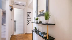 Hello wall art shelves plants books entrance area at Pleasant 1-bedroom flat in Petrarca in Livorno Student Accommodation