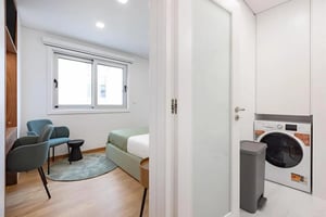 Bed chairs and washing machine bedroom study area at Charming studio close to the Brito Capelo metro station in Matosinhos Student Accommodation